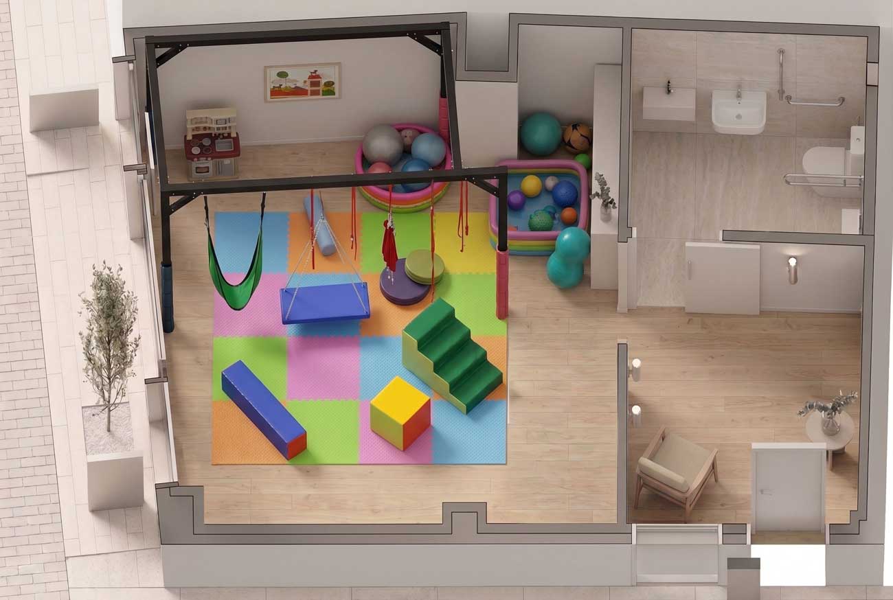 Vista aérea de una sala de terapia infantil, diseñada como sala de integración sensorial en Madrid, que cuenta con coloridas alfombras de juego, material de gimnasia, bloques de espuma, una piscina de bolas y una zona de aseos. Sala integración sensorial.